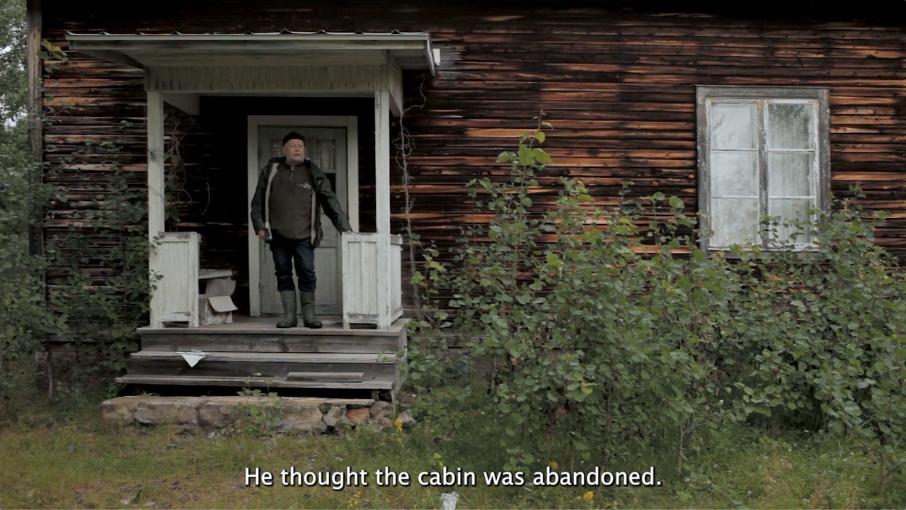 En man står på förstubron till en nedgången stuga. En textremsa säger: "He thought the cabin was abandoned"
