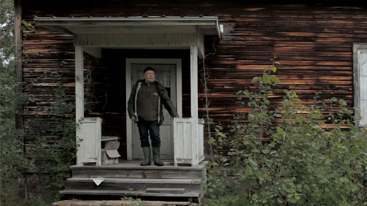 En man står på förstubron till en nedgången stuga. En textremsa säger: "He thought the cabin was abandoned"